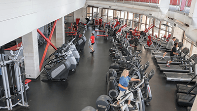 fitness room with people working out on various machines