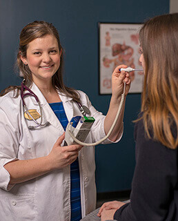 Katie taking a student's temperature