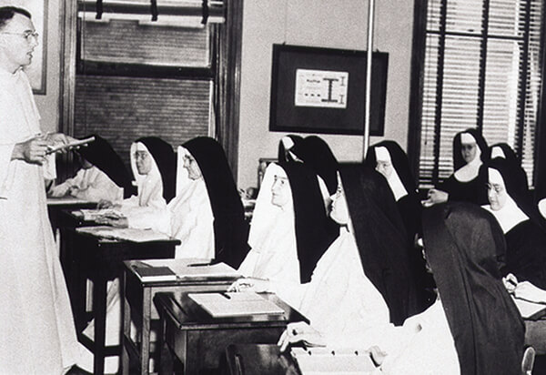 Fotografía en blanco y negro de las hermanas en un salón de clases aprendiendo sobre teología