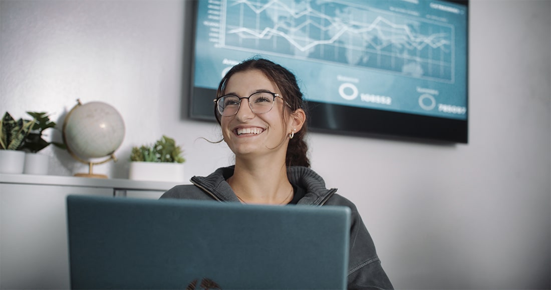 Girl with laptop smiling in class