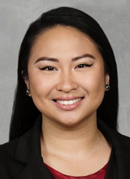 Johnna Gerona's headshot, they are wearing a black blazer and red top