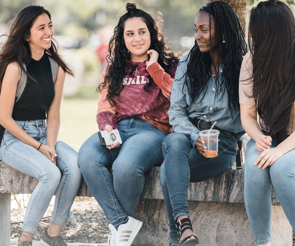 Four SXU students conversing on campus