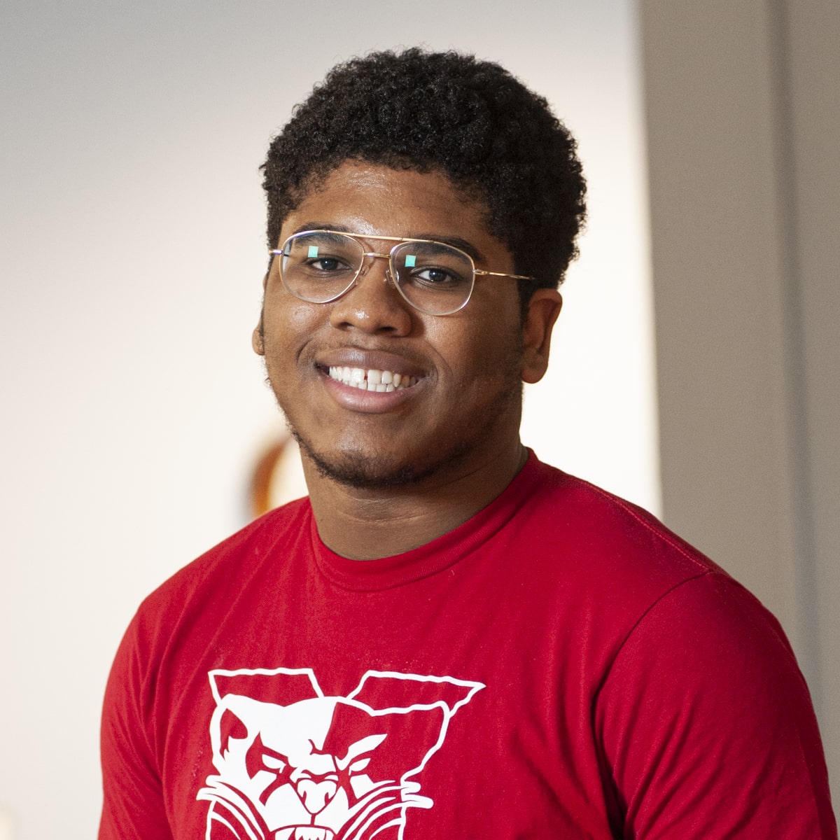 Student wearing SXU shirt smiling
