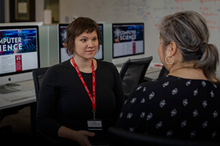 Two women speaking in a computer lab