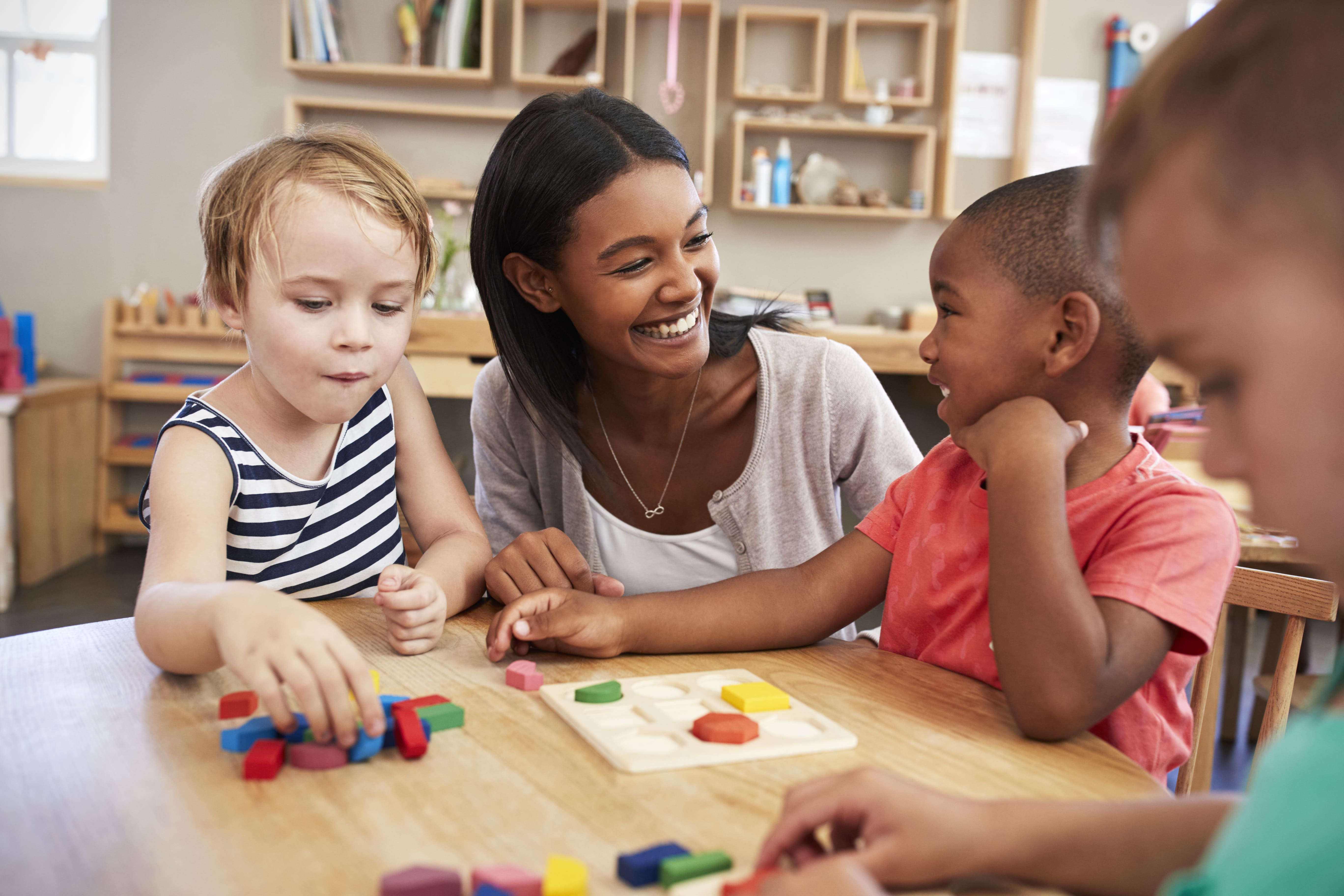 Teacher smiling while working with several students