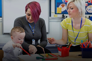 Two teachers working with young student