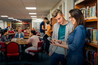 Teacher assisting high school student in the classroom