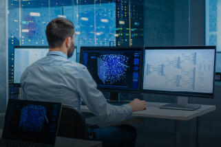 Man at computer with several screens